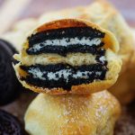 A fried oreo split in half and folded on top of whole fried oreo.