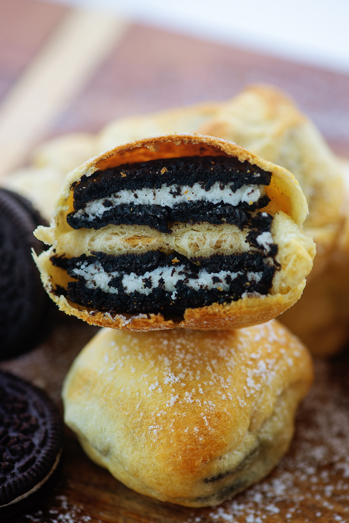 A fried oreo split in half and folded on top of whole fried oreo.