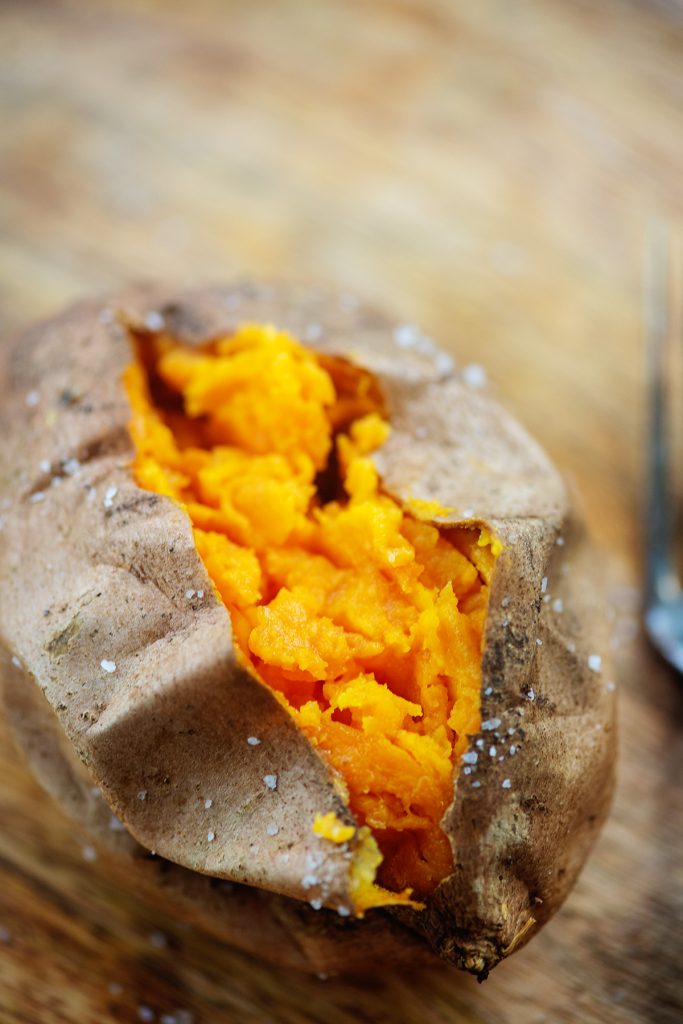 A close up of a sweet potato split down the middle.