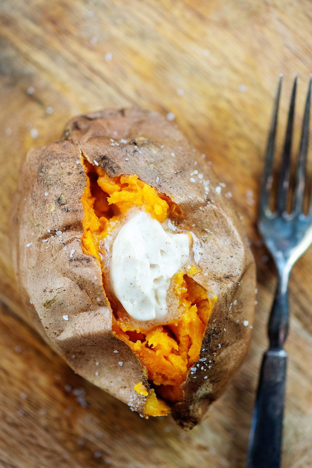 An overhead view of a sweet potatoe topped with butter.