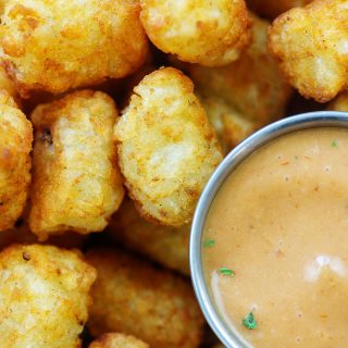 Overhead view of a close up of tater tots and dip.
