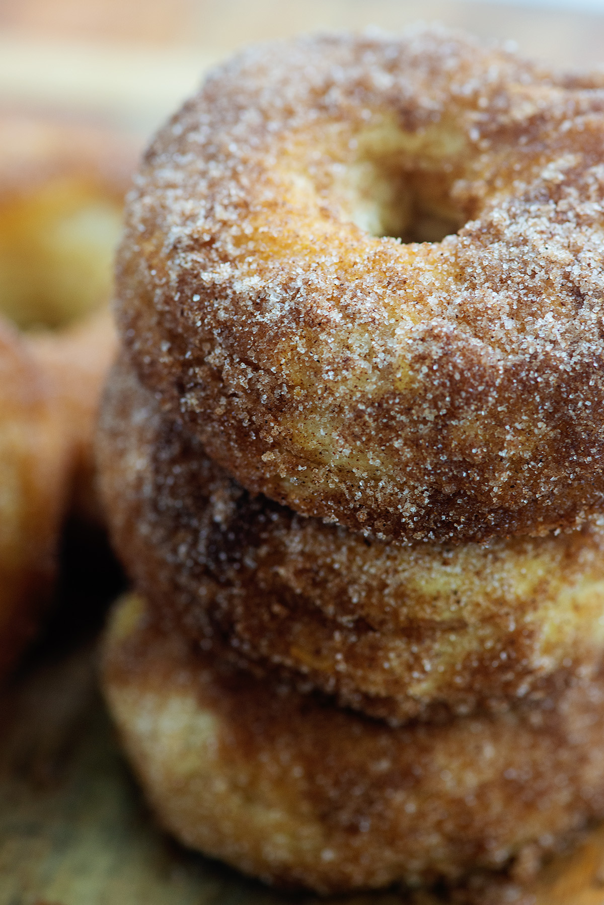 A stack of three biscuit donuts covered in cinnamon and sugar