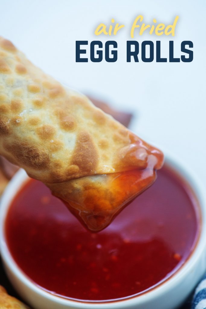 A close up of an egg roll that was dipped into sweet and sour sauce
