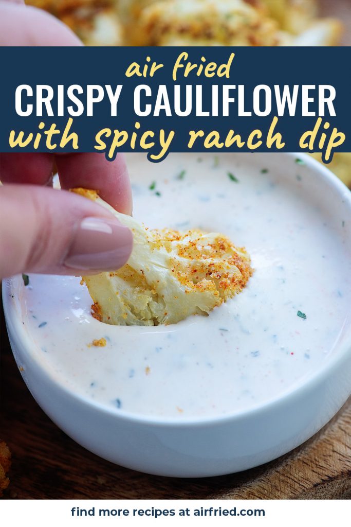 A woman dipping a piece of cauliflower into a spicy ranch dip.