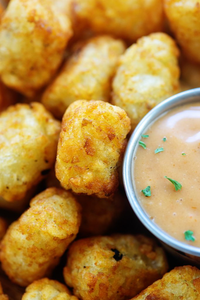 A close up of a pile of tater tots