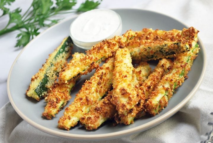 A bunch of air fried zucchini on a plate.