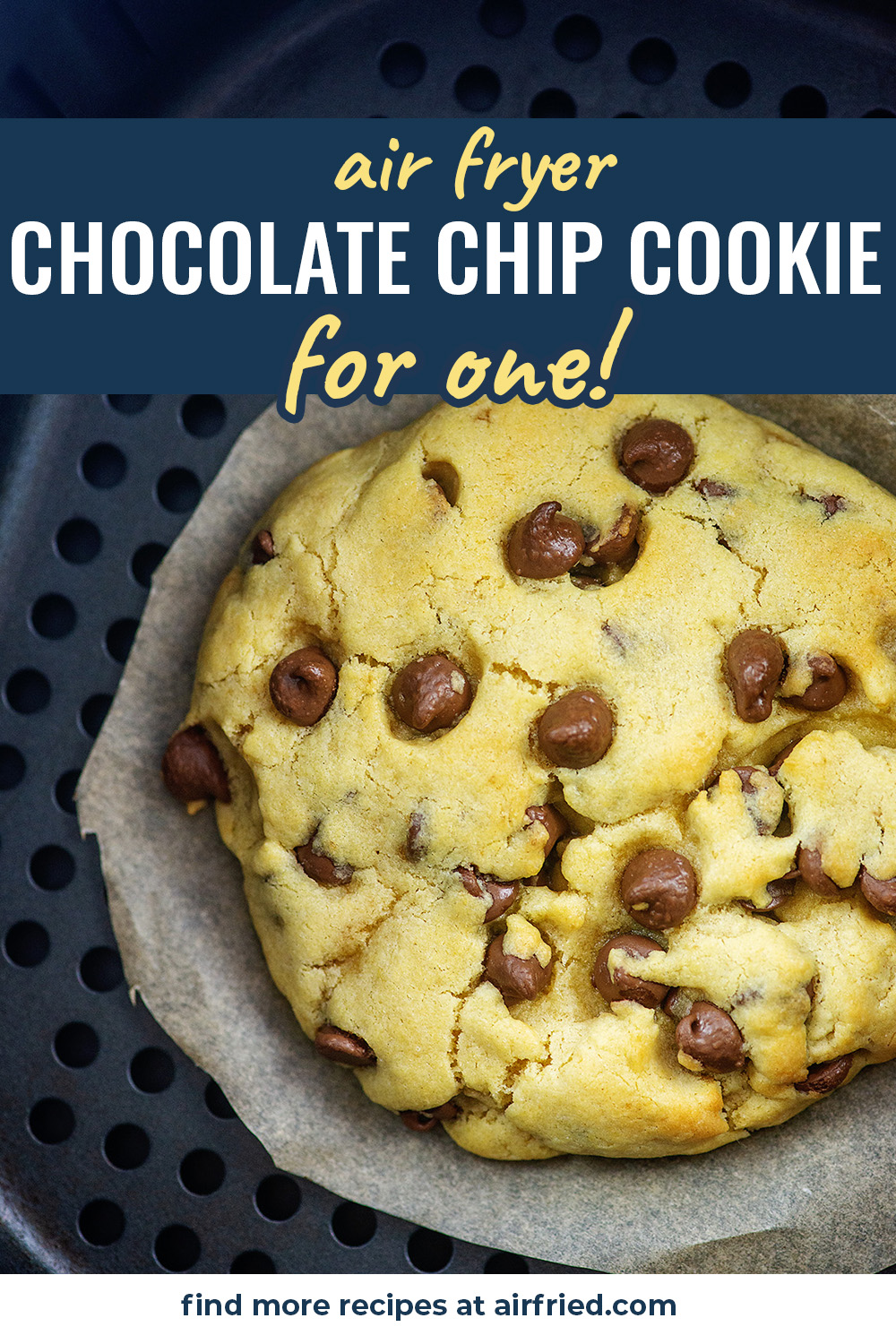 A big chocolate chip cookie in an air fryer basket.