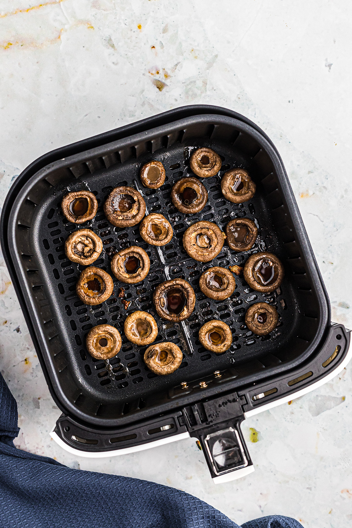 overhead view of cooked mushrooms in an air fryer basket