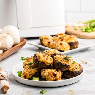 mushrooms on a plate in front of an air fryer