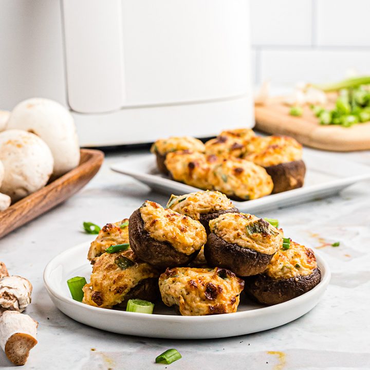 mushrooms on a plate in front of an air fryer
