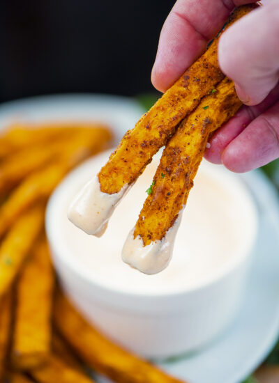 Fries being dipped in spicy mayo.