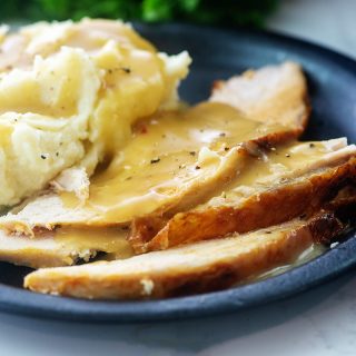 Mashed potatoes and gravy on a plate with turkey breast.