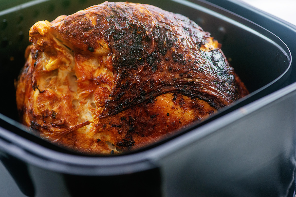 A turkey breast in an air fryer basket