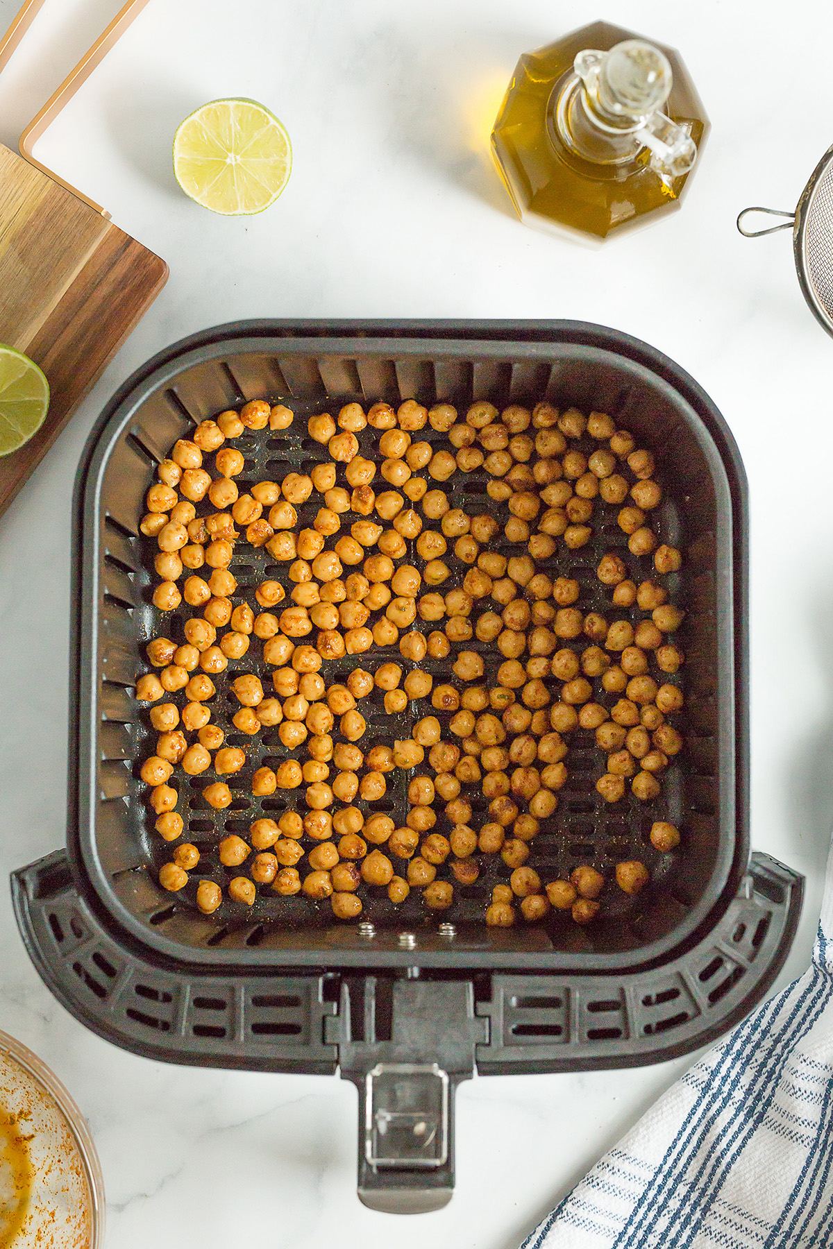 Overhead view of chickpeas spread out in an air fryer basket