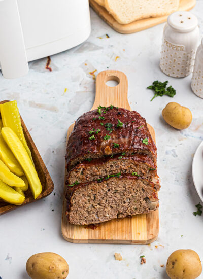 A meatloaf partially sliced on a small cutting board