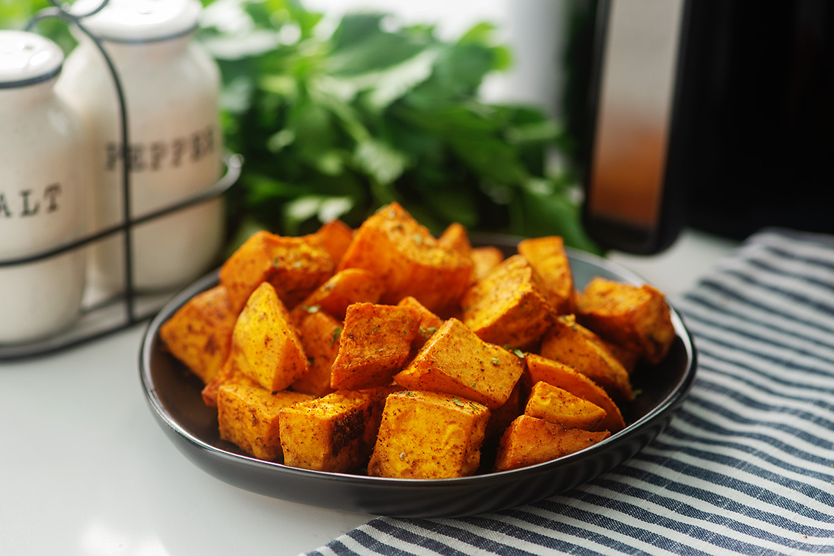 sweet potato cubes on a plate in front of salt and pepper shakers