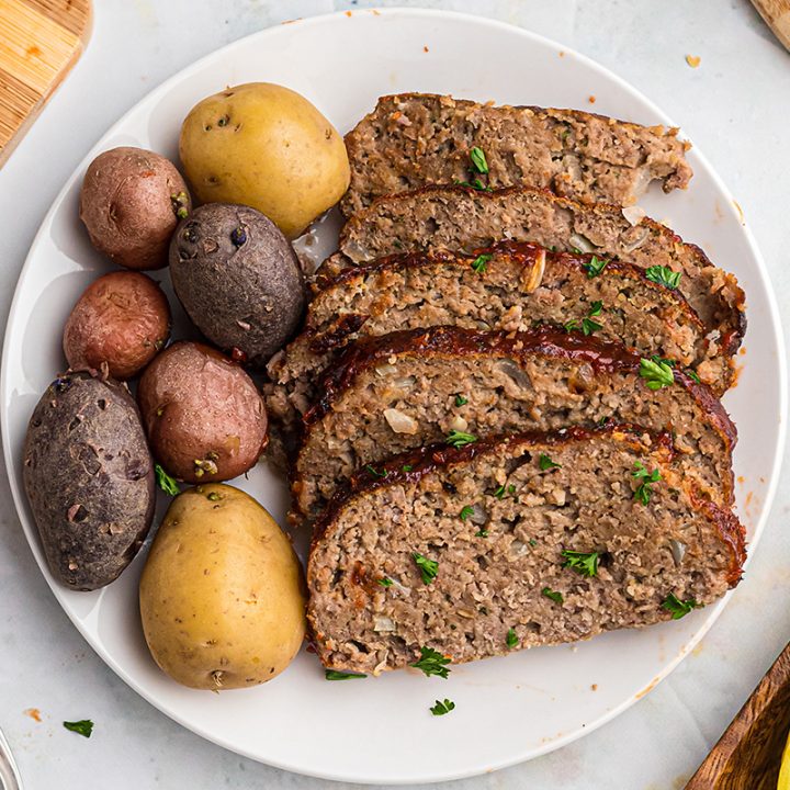Sliced meatloaf and potatoes on a white plate