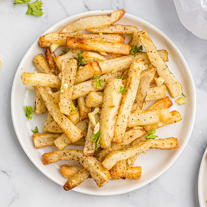 A close up of two plates of french fries side by side