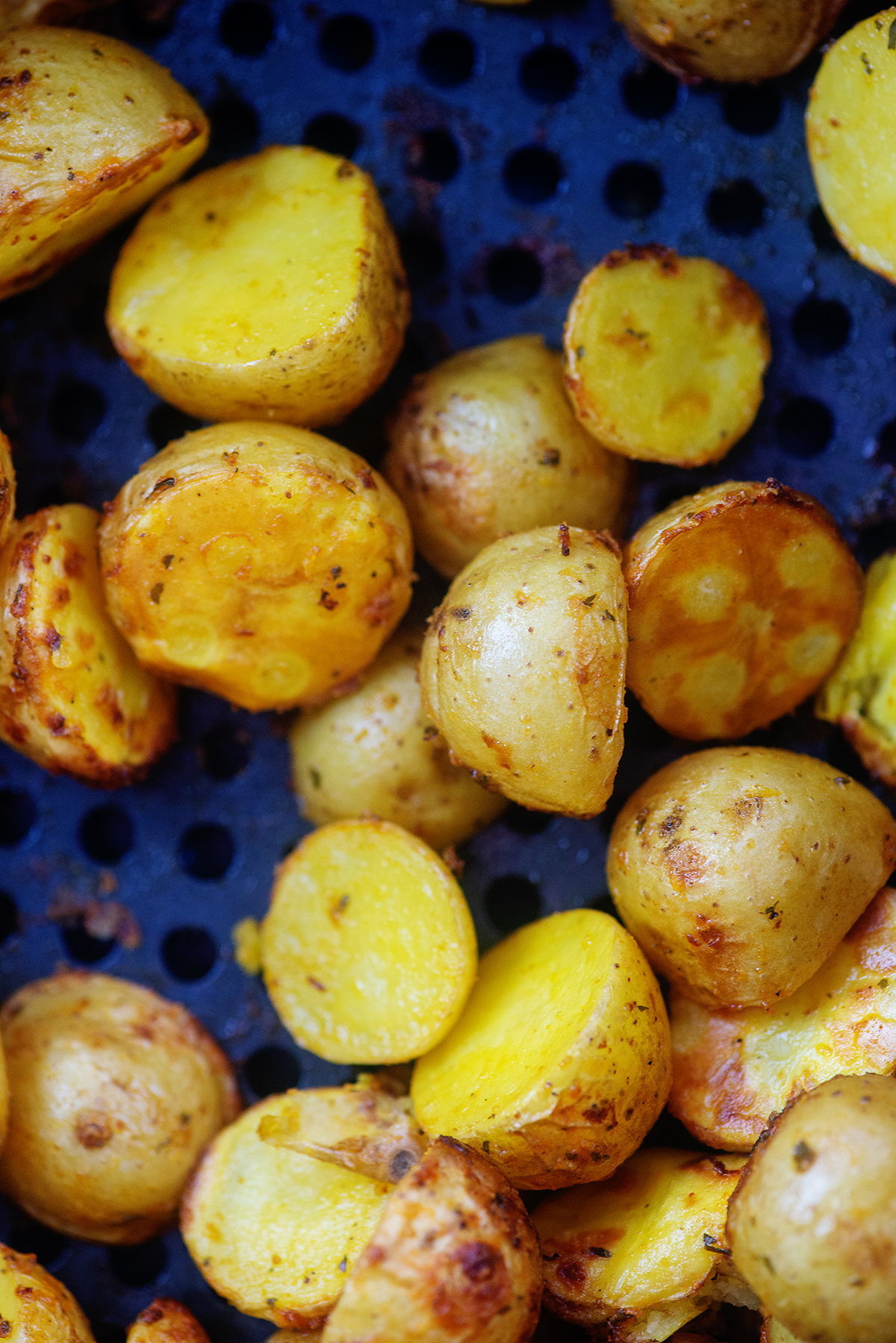 potato halves in an air fryer basket