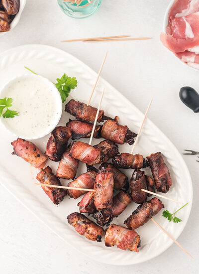 Toothpicks and bacon wrapped dates spread out on a table