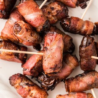 Close up of bacon wrapped dates with toothpicks in them.