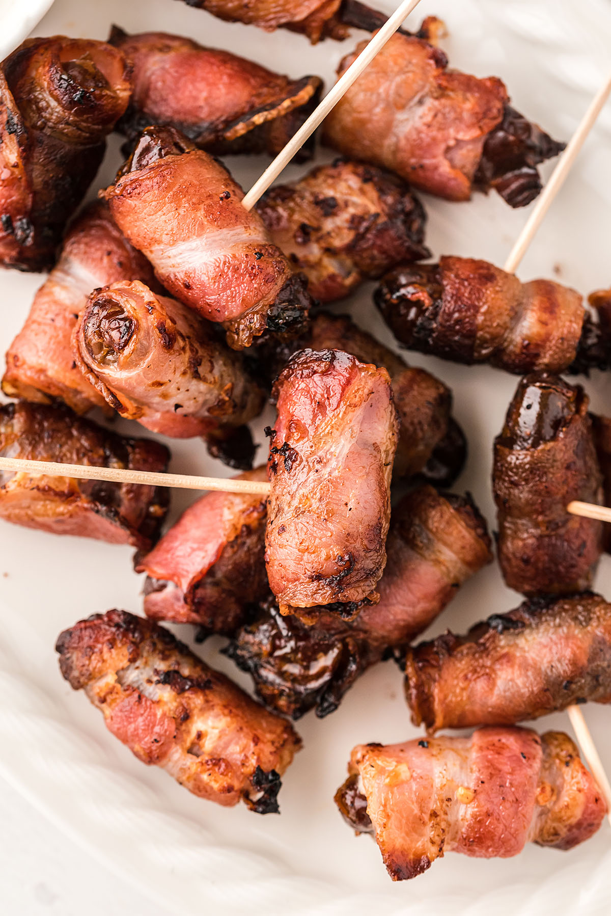 Close up of bacon wrapped dates with toothpicks in them.