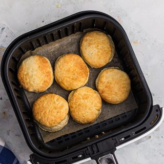 Overhead view of biscuits in an air fryer basket.