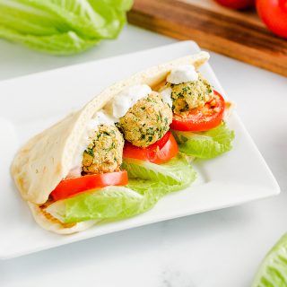 close up of a falafel pita on a square plate