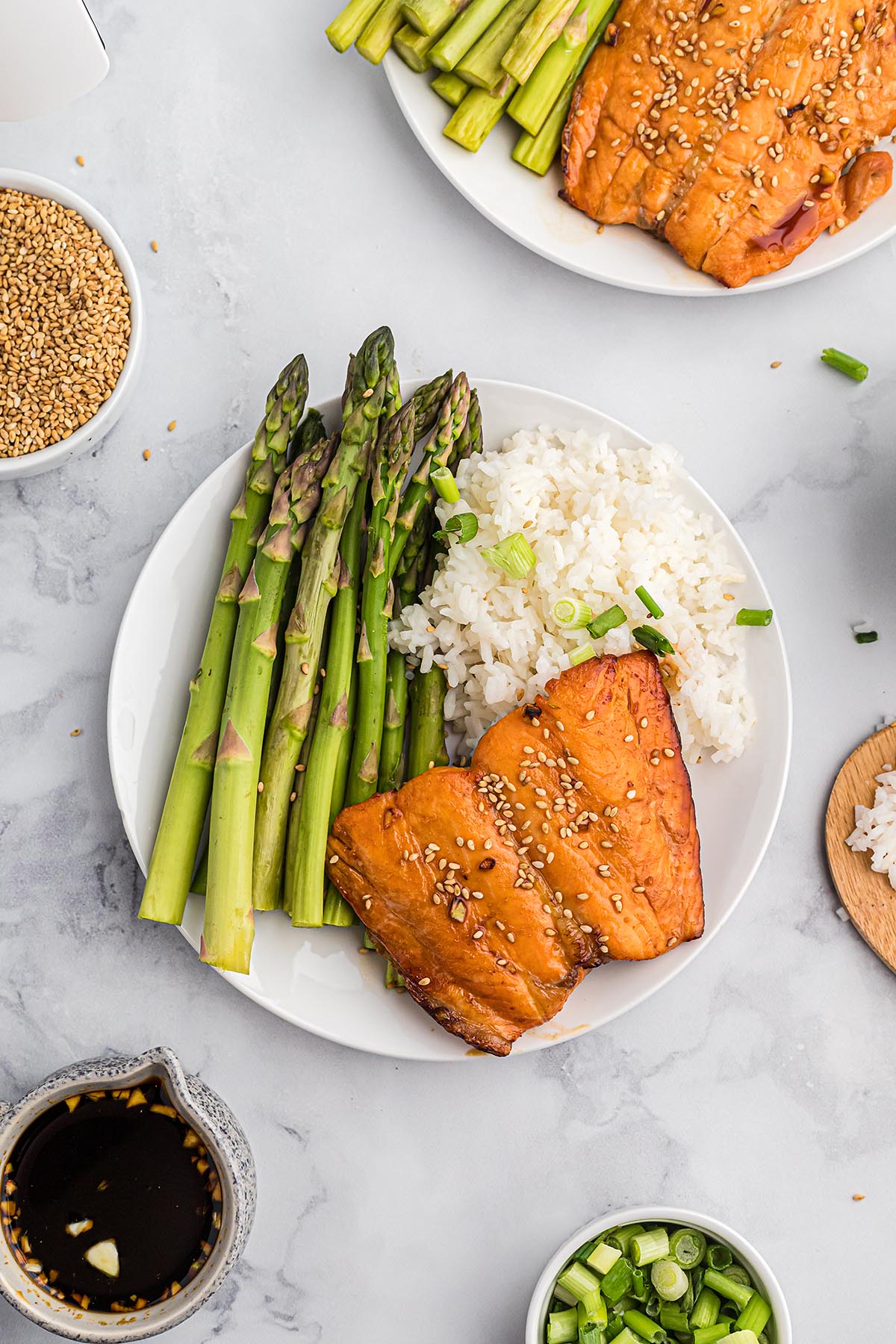 Overhead view of rice, salmon, and asparagus on a white plate.