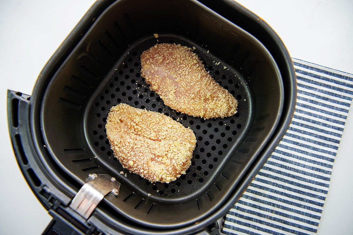 breaded chicken in an air fryer basket