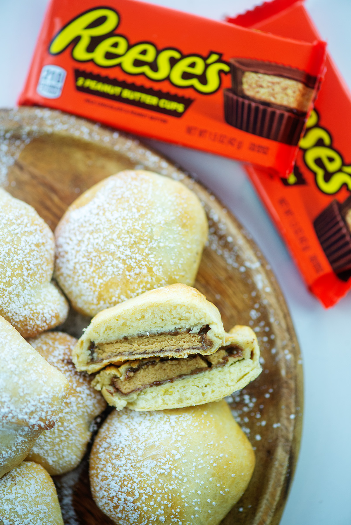 Closeup overhead view of fried peanut butter cups on a wooden plate