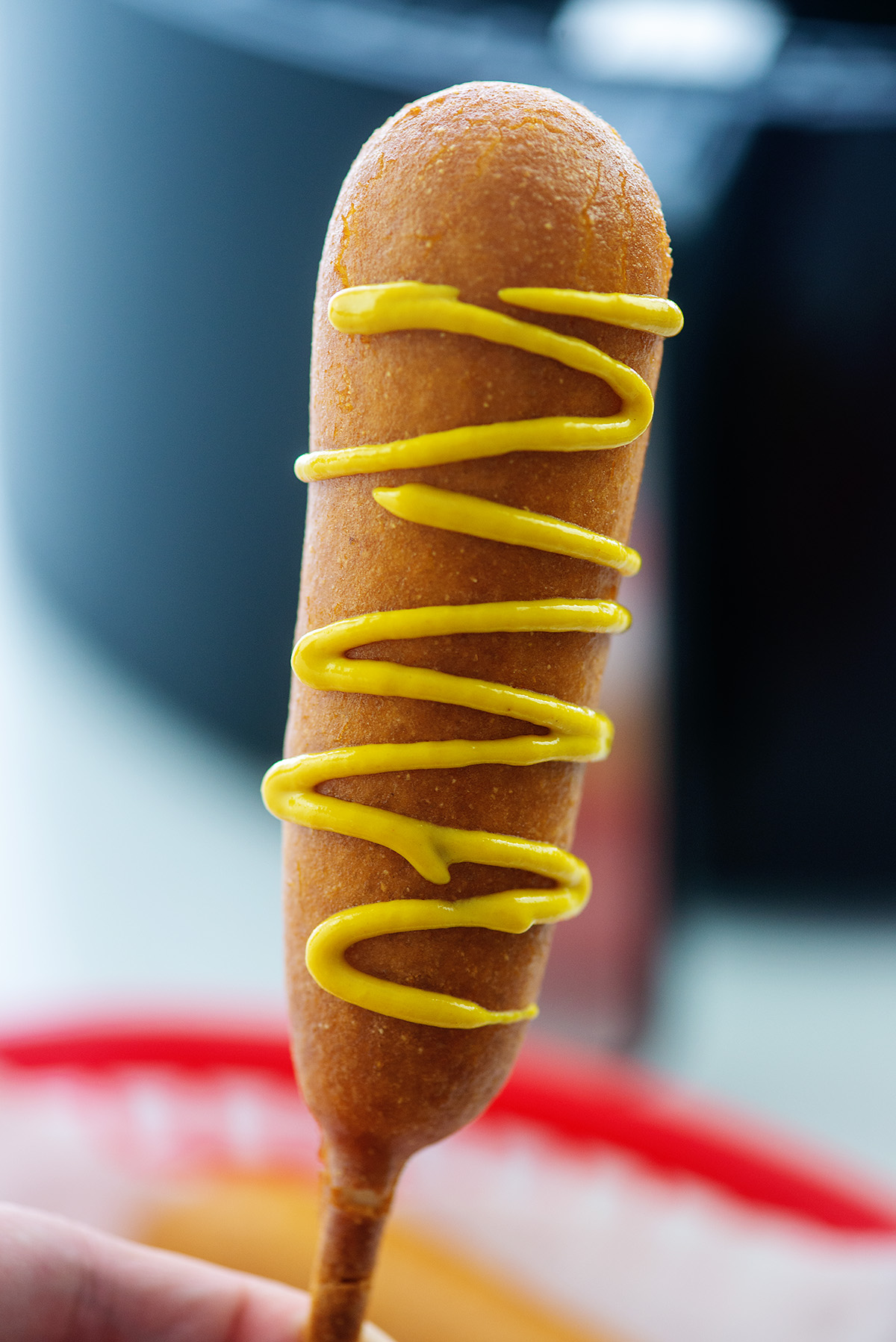 corn dog drizzled with mustard.