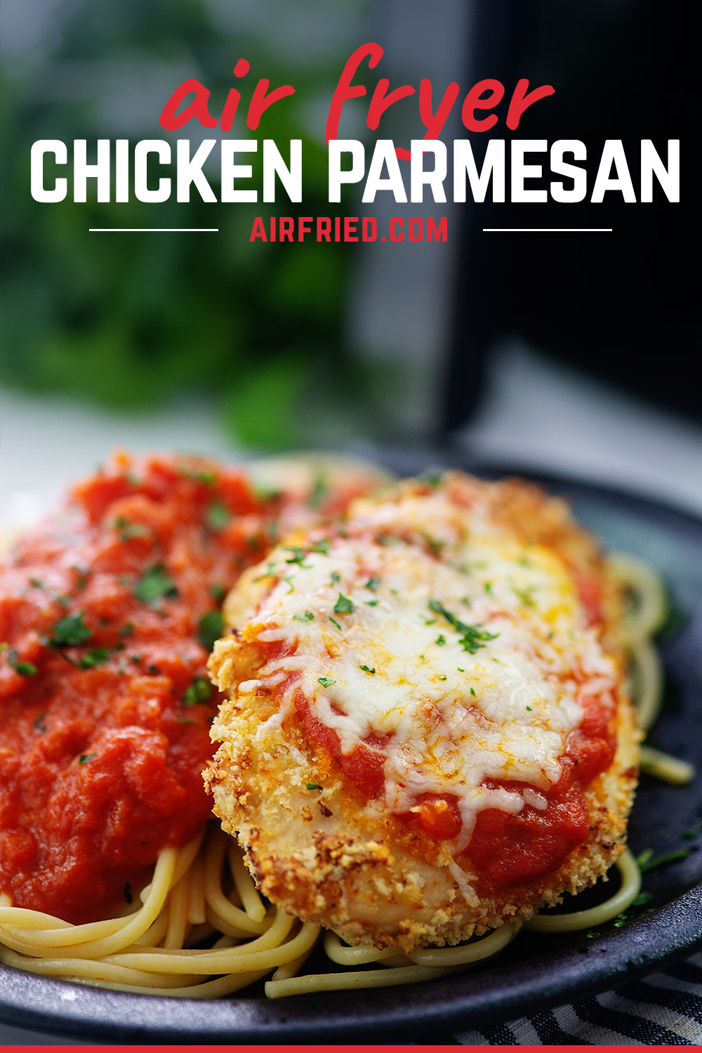 Chicken parmesan and spaghetti on a black plate