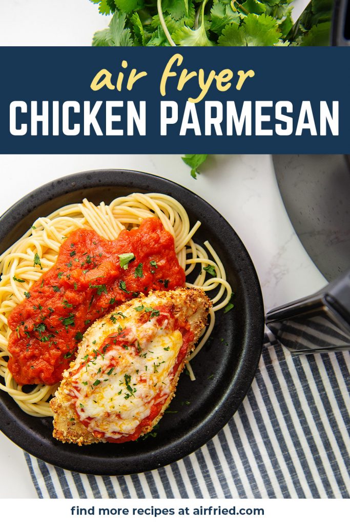 Overhead view of chicken parmesan on a black plate