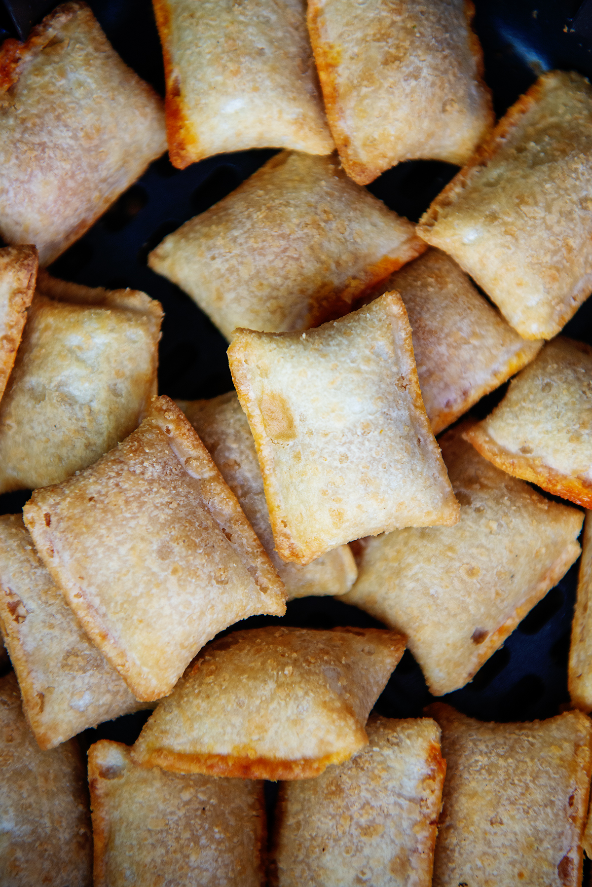 Cooked pizza rolls in an air fryer basket