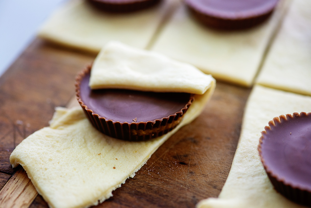 A peanut butter cup partially wrapped in dough.