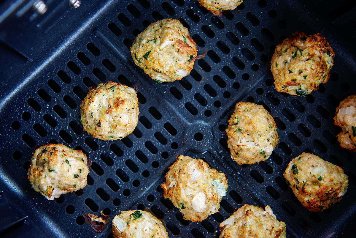 cooked turkey meatballs in an air fryer basket