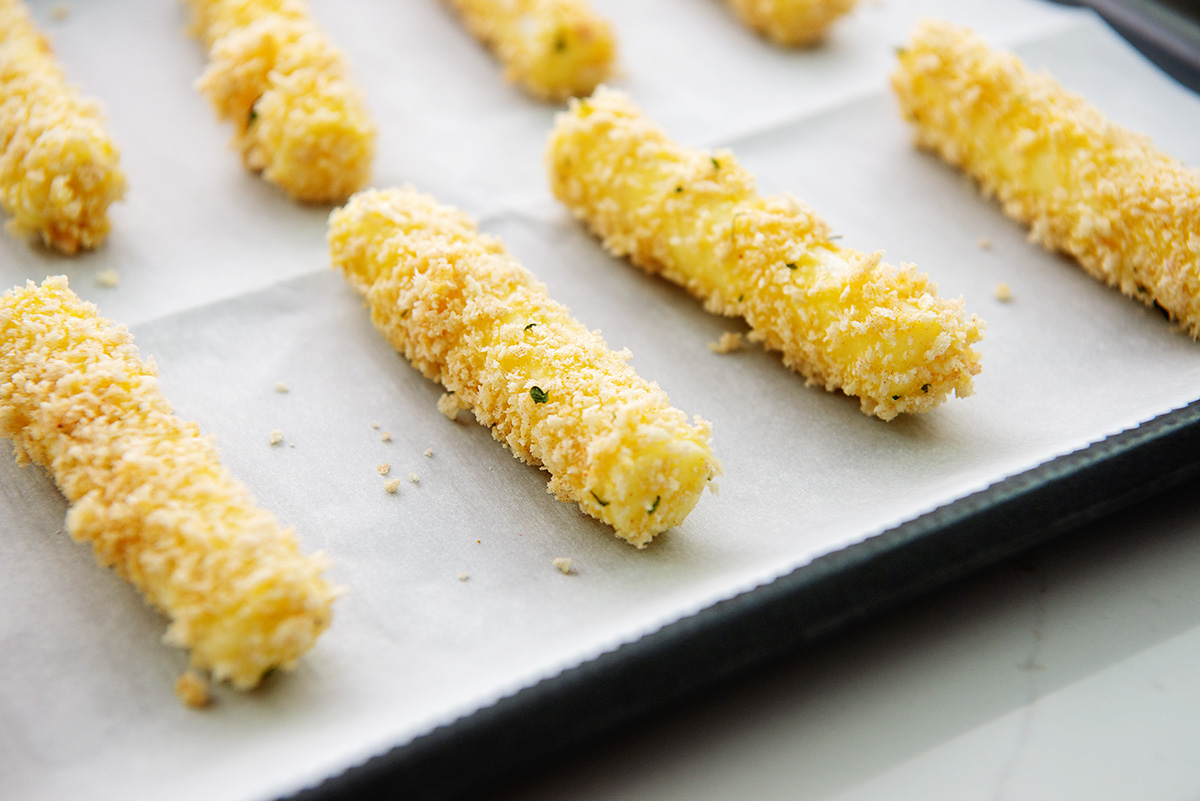 Breaded cheese sticks on a baking dish