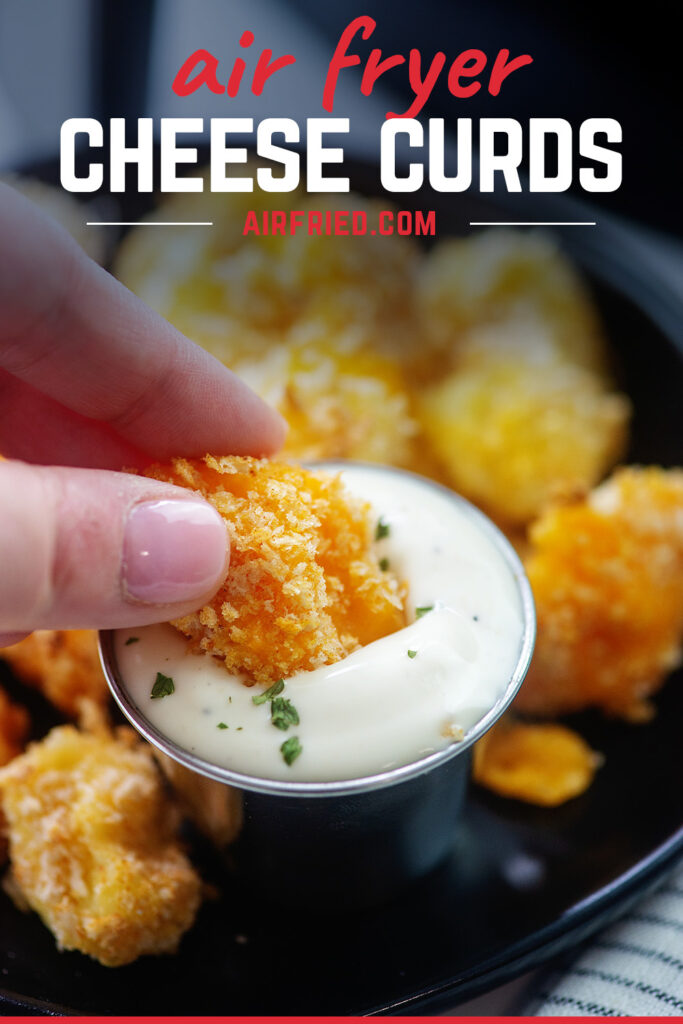Close up of a woman dipping a cheese curd into ranch dip