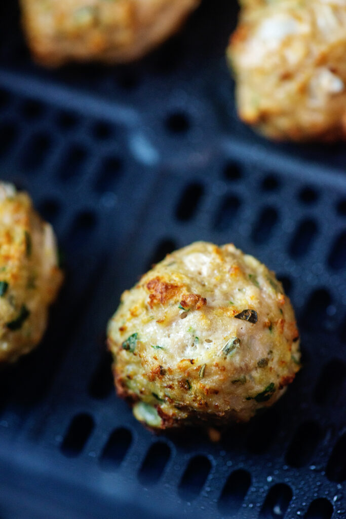 close up of a cooked turkey meatball in an air fryer basket