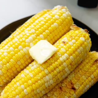 Butter on top of a pile of corn on the cob
