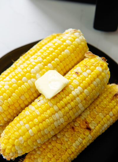 Butter on top of a pile of corn on the cob