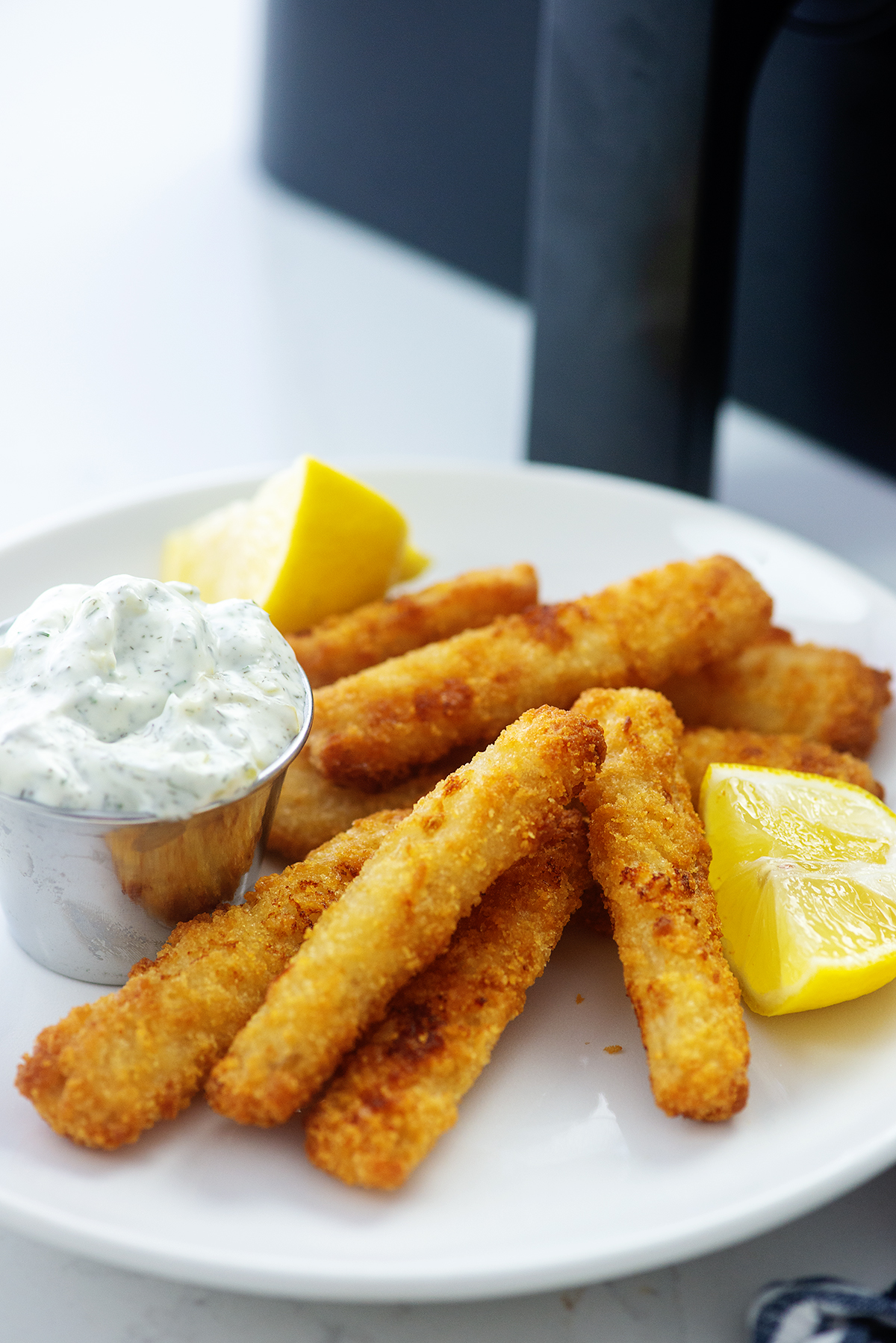 Fish sticks piled on a white plate