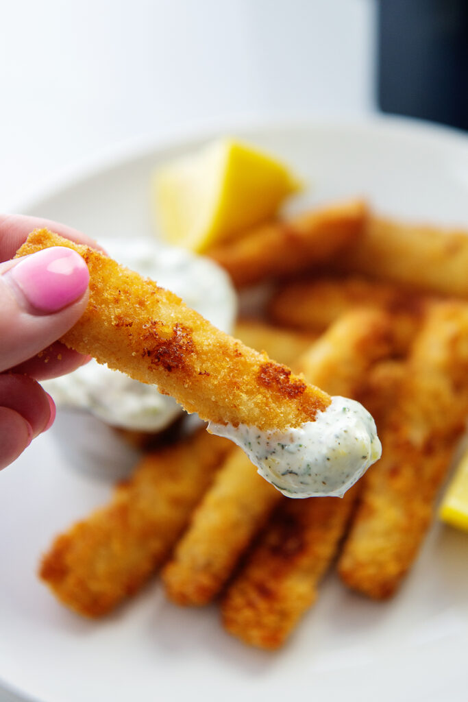 close up of a woman holding a fish stick