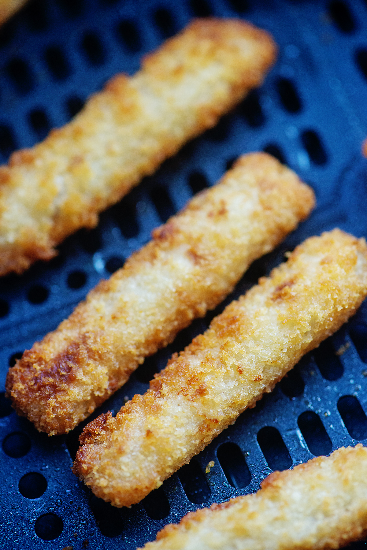 cooked fish sticks in an air fryer basket