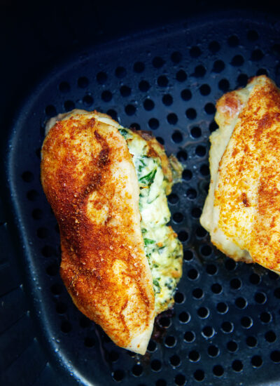 overhead view of stuffed chicken breasts in an air fryer basket
