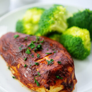 BBQ chicken and broccoli on a small white plate