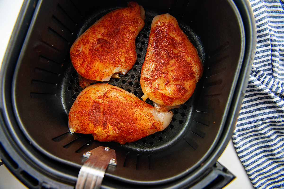 raw chicken in an air fryer basket