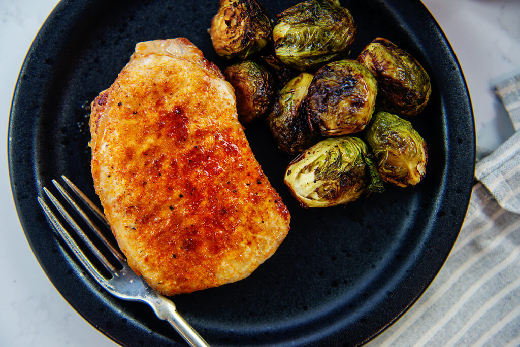 Overhead view of a pork chop and brussel sprouts