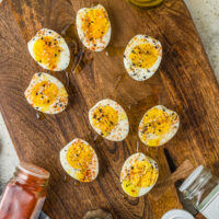Seasoned hard boiled eggs on a wooden serving tray
